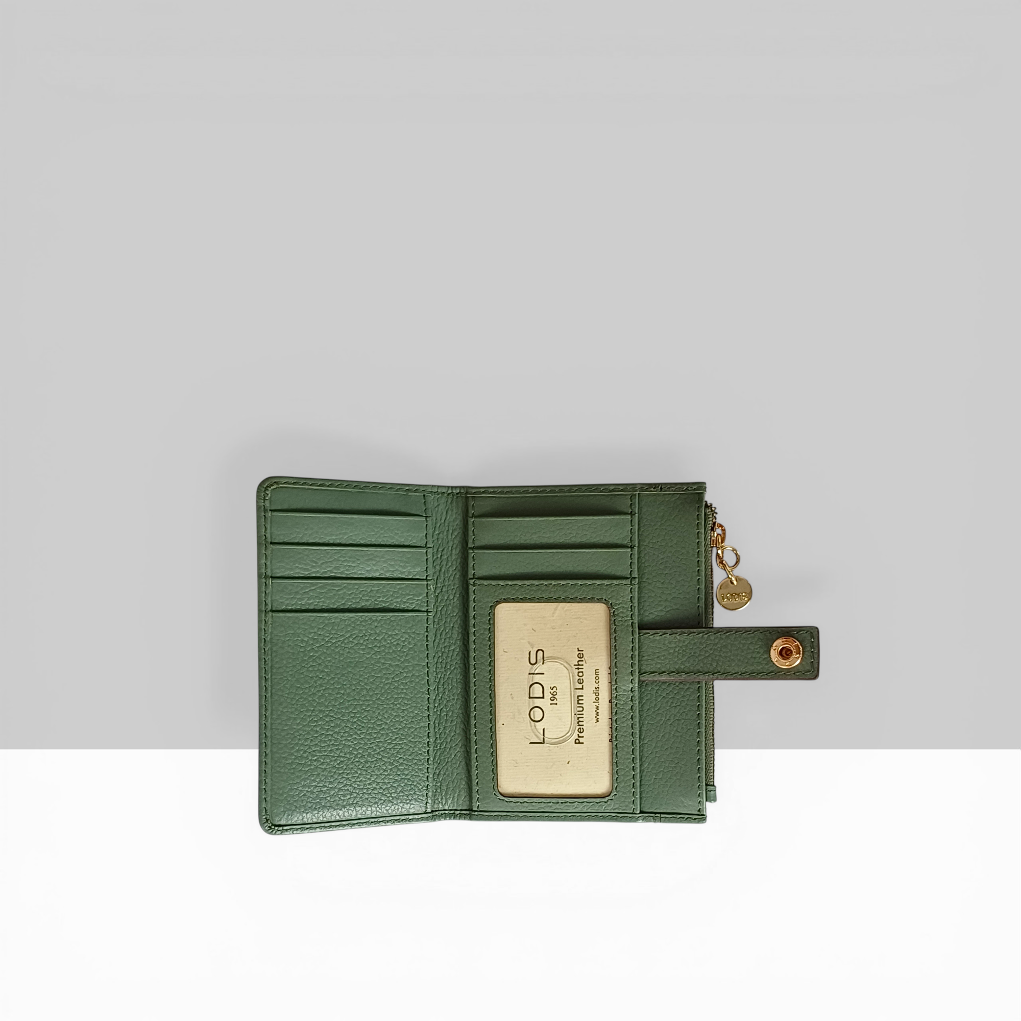 Lodis Kiara Flip Face Wallet in sage green pebbled leather fully open showing multiple card slots, bill compartment, and Lodis branded interior