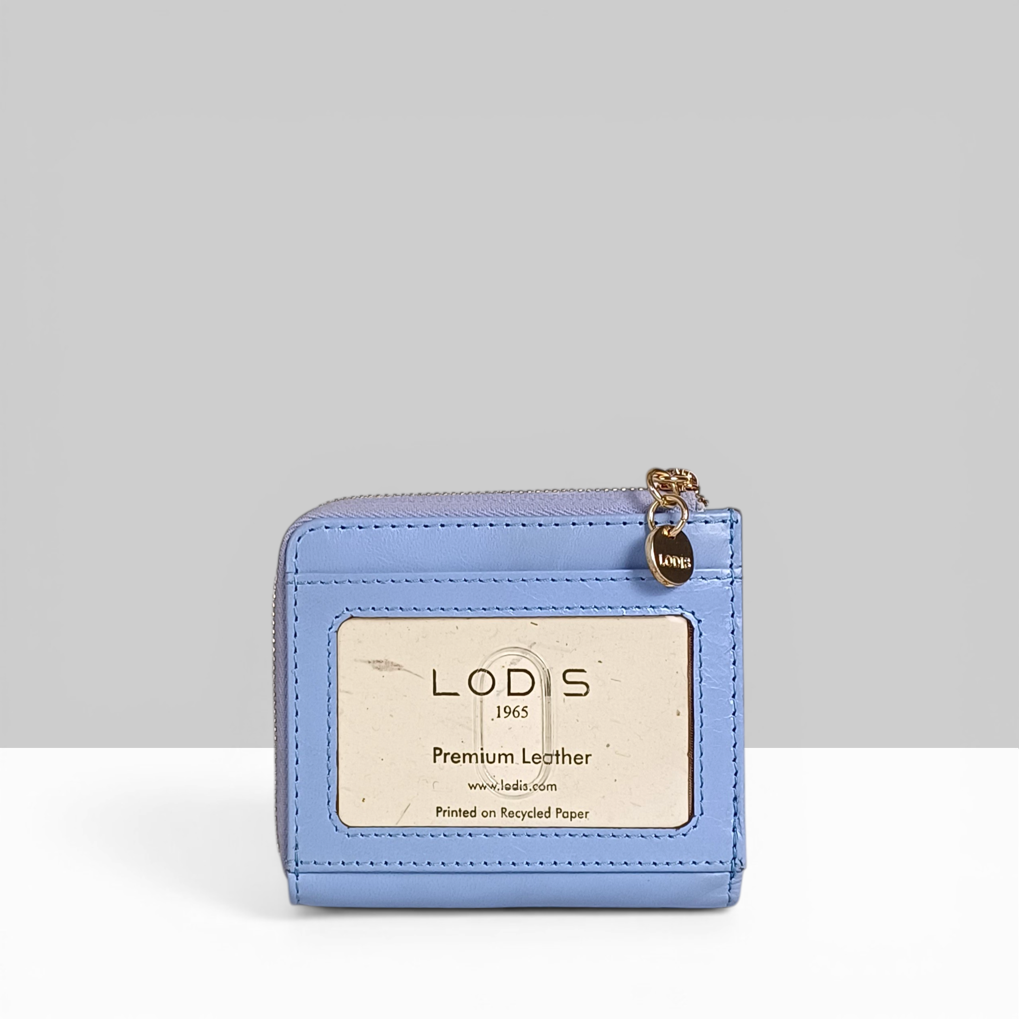 Overglow French L Zip Wallet in Aura Blue Pebbled Leather – Back View Showing Lodis 1965 Premium Leather Branding Card and Gold Zip Charm | Lodis 1965