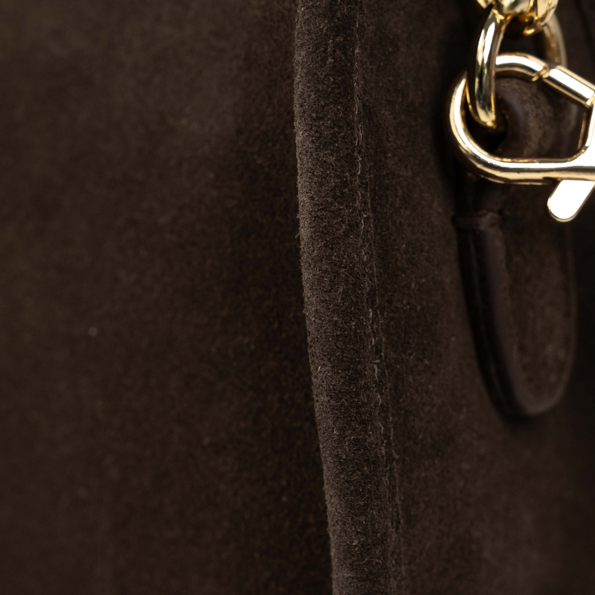 Lodis Axis Crossbody in Brown - Side Detail of Gold-Tone Swivel Clasp and Texas Leather Strap Tab on Dark Brown Suede | Lodis 1965