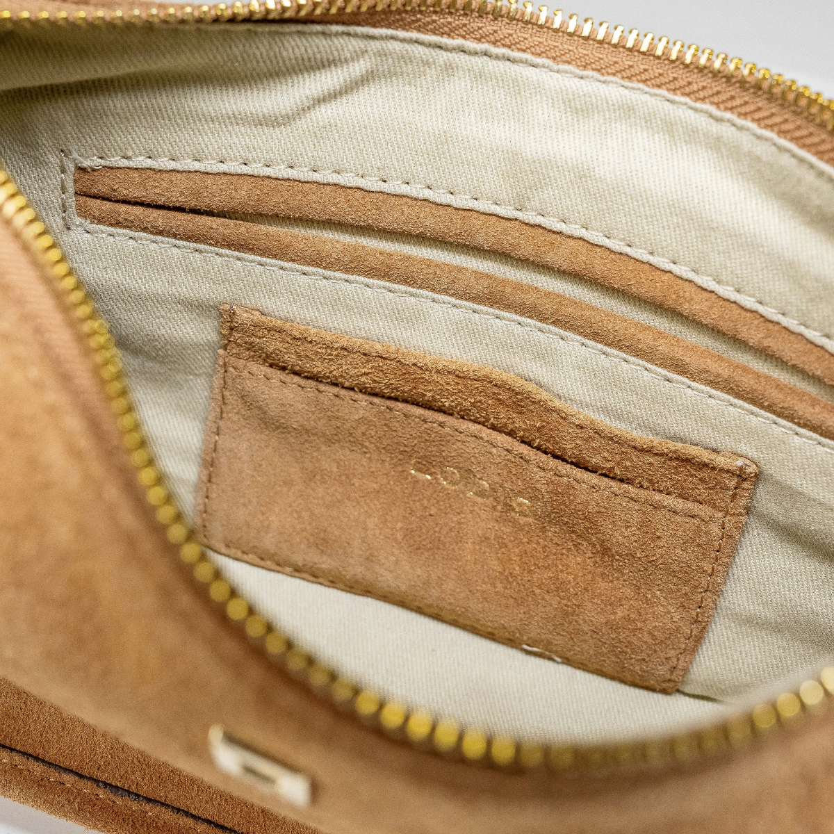 Lodis Axis Crossbody in Tan - Interior View Showing Gold-Tone Zip Opening, Suede Slip Pocket and Light Fabric Lining | Lodis 1965