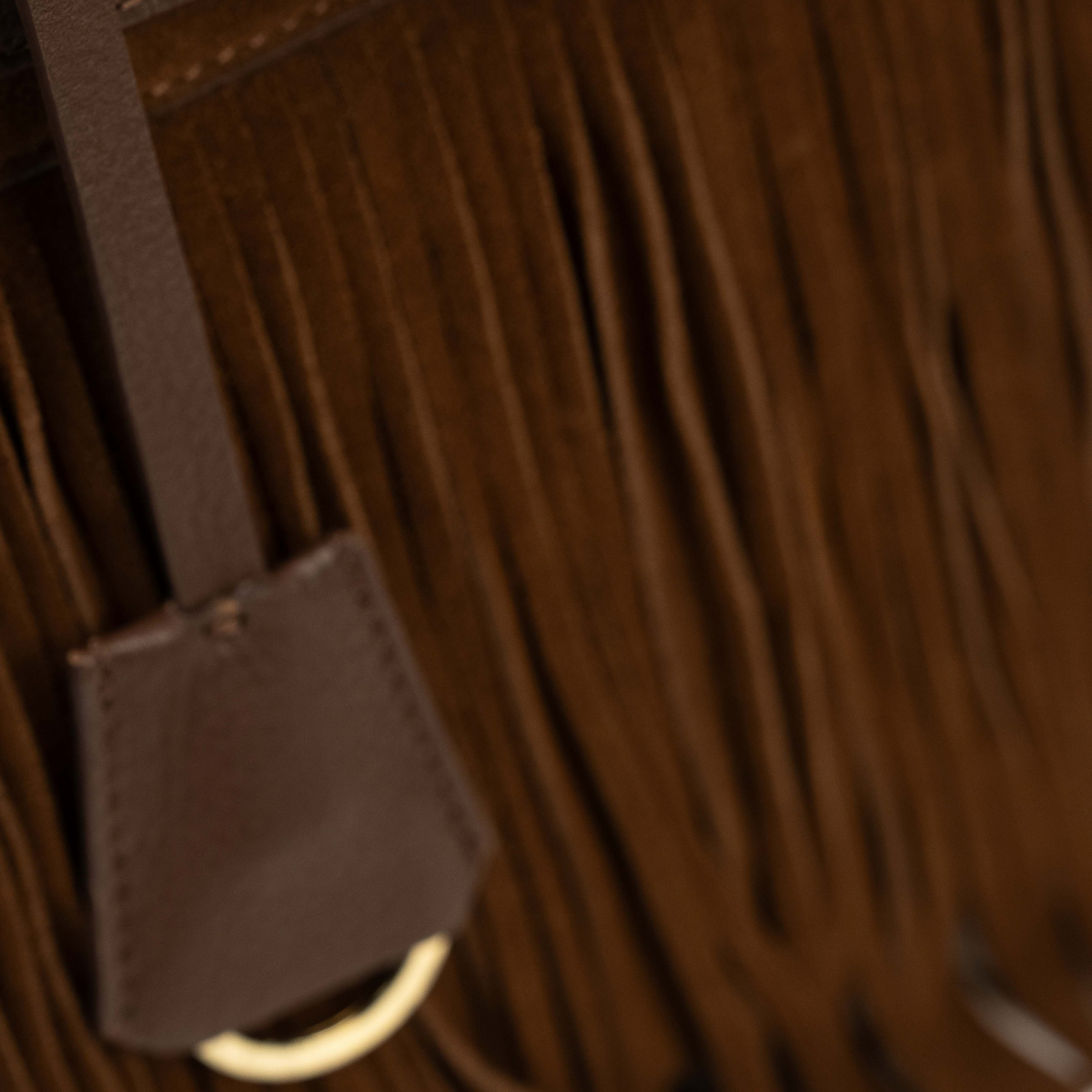 Lodis Ceres Satchel in Brown - Detail of Texas Leather Hang Tag with Gold-Tone Ring Against Suede Fringe | Lodis 1965