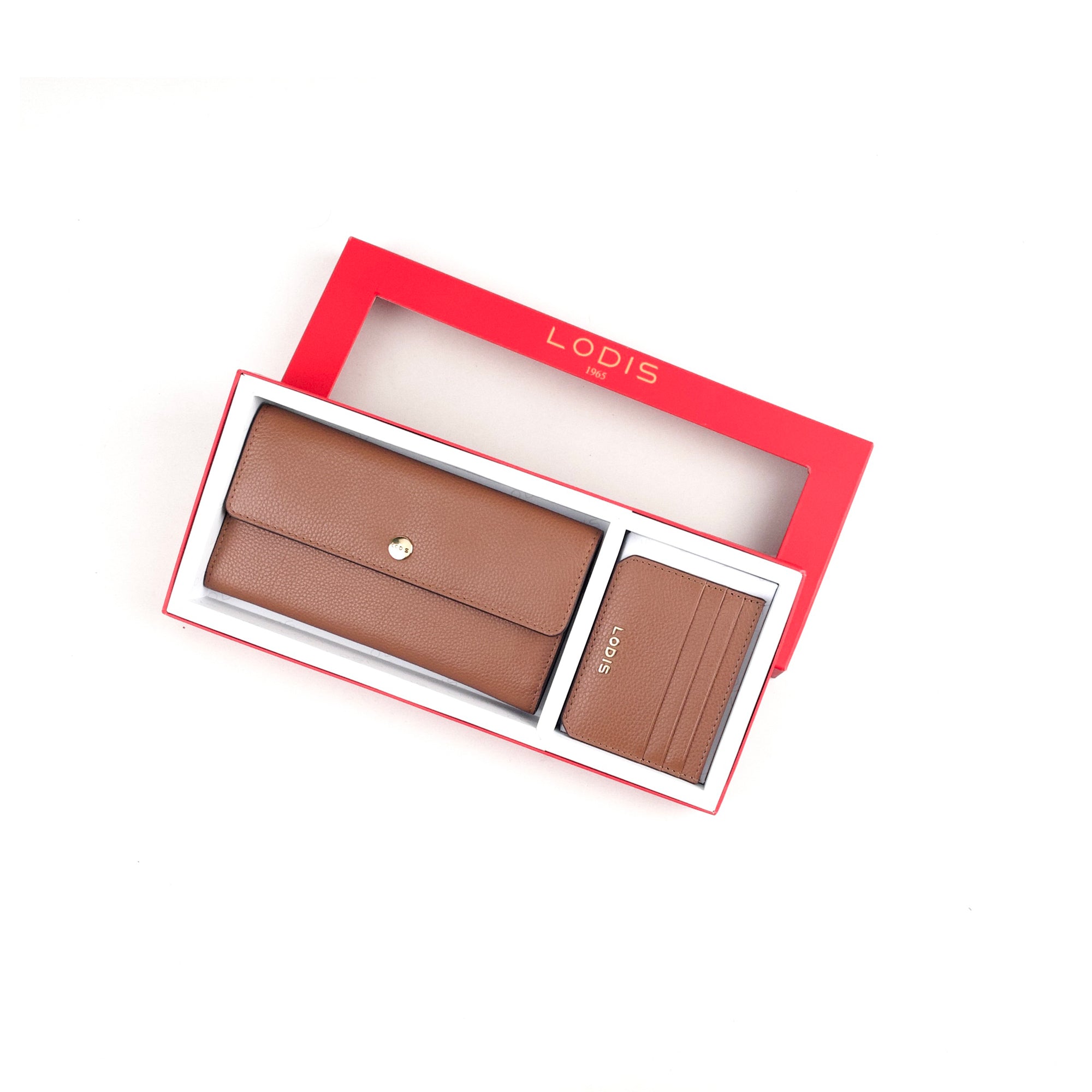 Lodis Kate Large Flap Wallet and Card Case in Tan – Angled View Partially Out of Gift Box, Showing Pebbled Leather Texture and Gold-Tone Turn-Lock | Lodis 1965