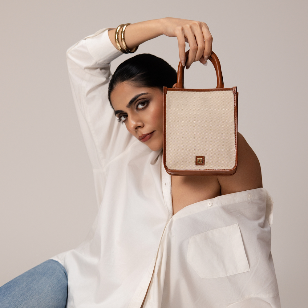 Woman Holding Lodis Kiara City Crossbody in Chestnut – Lifestyle Shot in White Shirt and Jeans, Casual Everyday Style | Lodis 1965