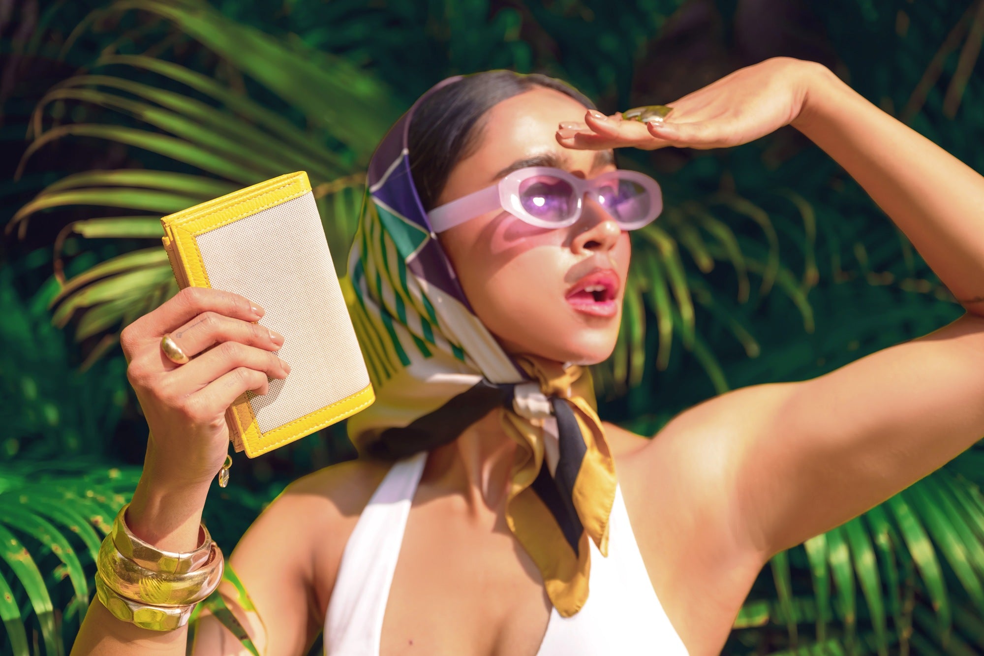 Woman Holding Lodis Kiara French Purse in Curry – Tropical Lifestyle Shot with Summer Outfit and Accessories | Lodis 1965