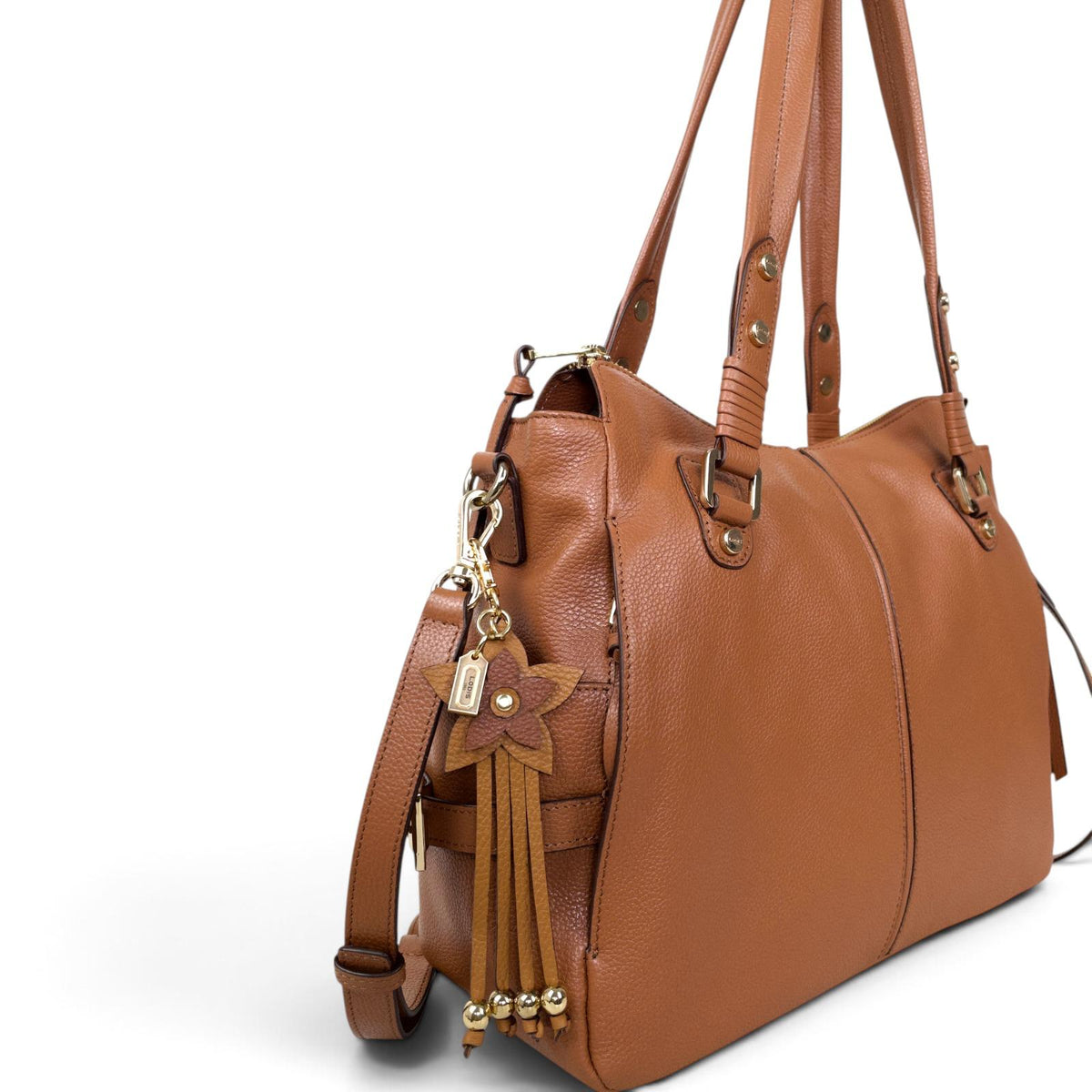 Lodis Leather Flower Bag Charm in Tan Clipped to a Cognac Leather Shoulder Bag - Shown as a Handbag Accessory with Fringe Tassels and Gold-Tone Clasp | Lodis 1965