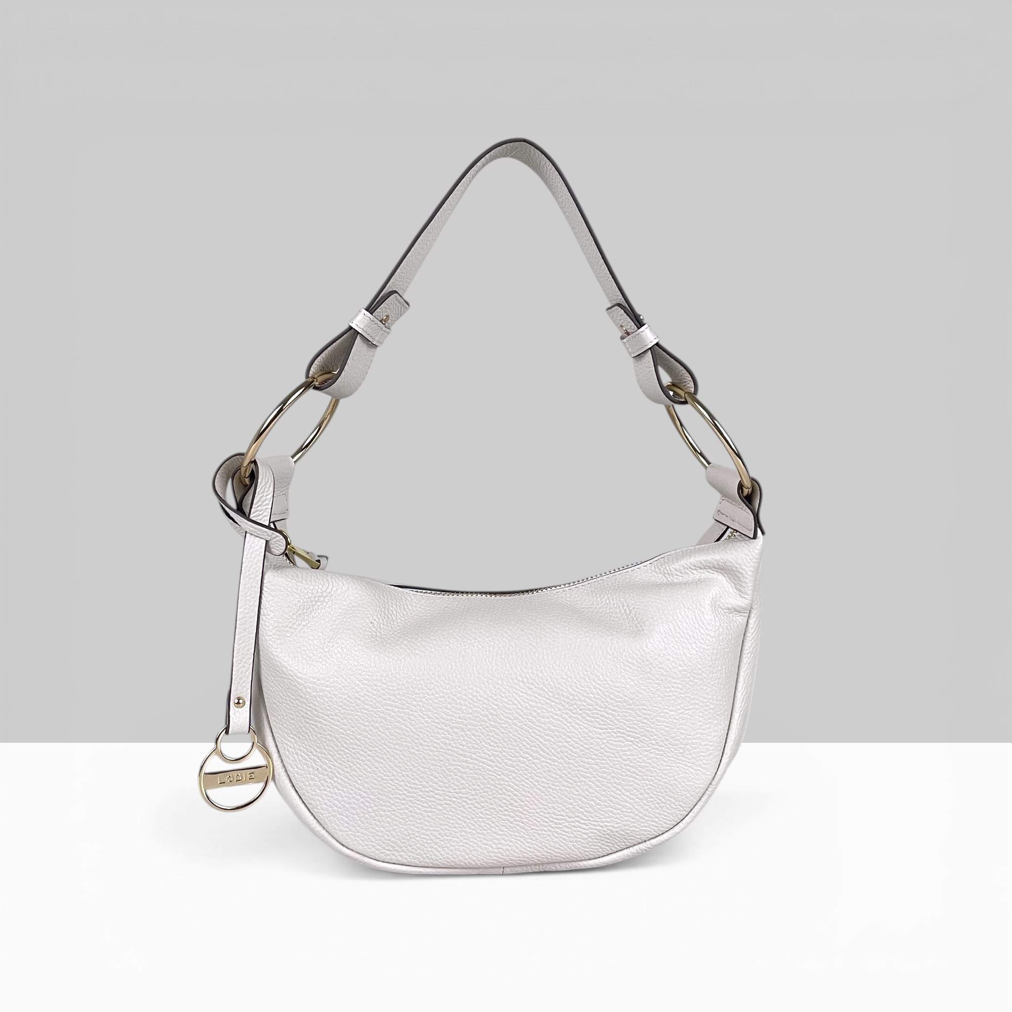 Lodis Solaris Hobo Bag in White – Front View, Drum Dyed Pebbled Leather Crescent Silhouette with Zip Closure, Gold-Tone D-Ring Hardware, and Logo Coin Charm | Lodis 1965