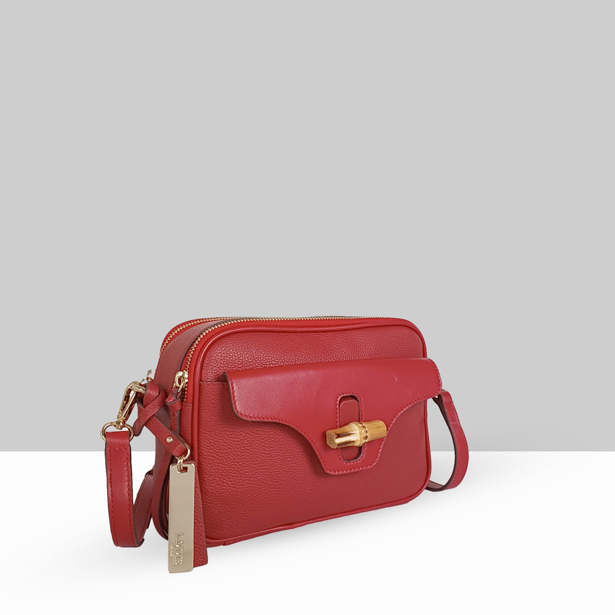 Lodis Sondra Camera Bag in Rhythmic Red – Angled View Showing Zip Top Compartment, Bamboo Turn-Lock Flap, and Gold-Tone Lodis Tag | Lodis 1965