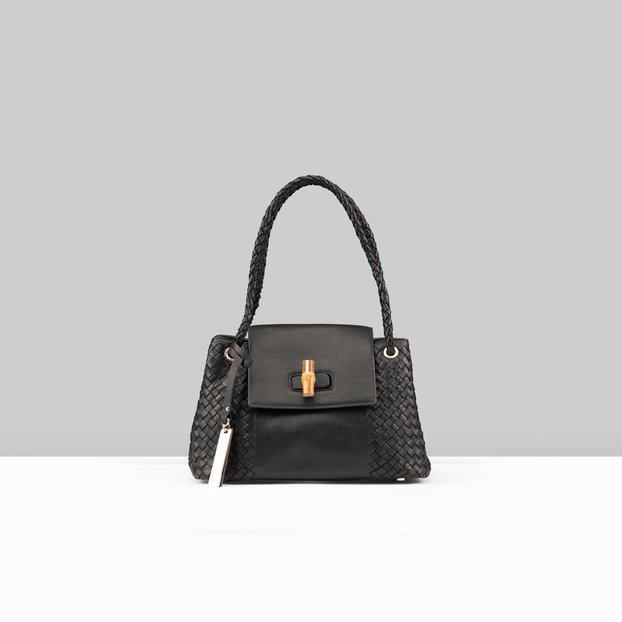 Lodis Sondra Satchel in Black – Front View, Drum Dyed Pebbled Leather with Woven Body Panels, Braided Handle, Bamboo Turn-Lock, and Contrast Cream Tassel | Lodis 1965