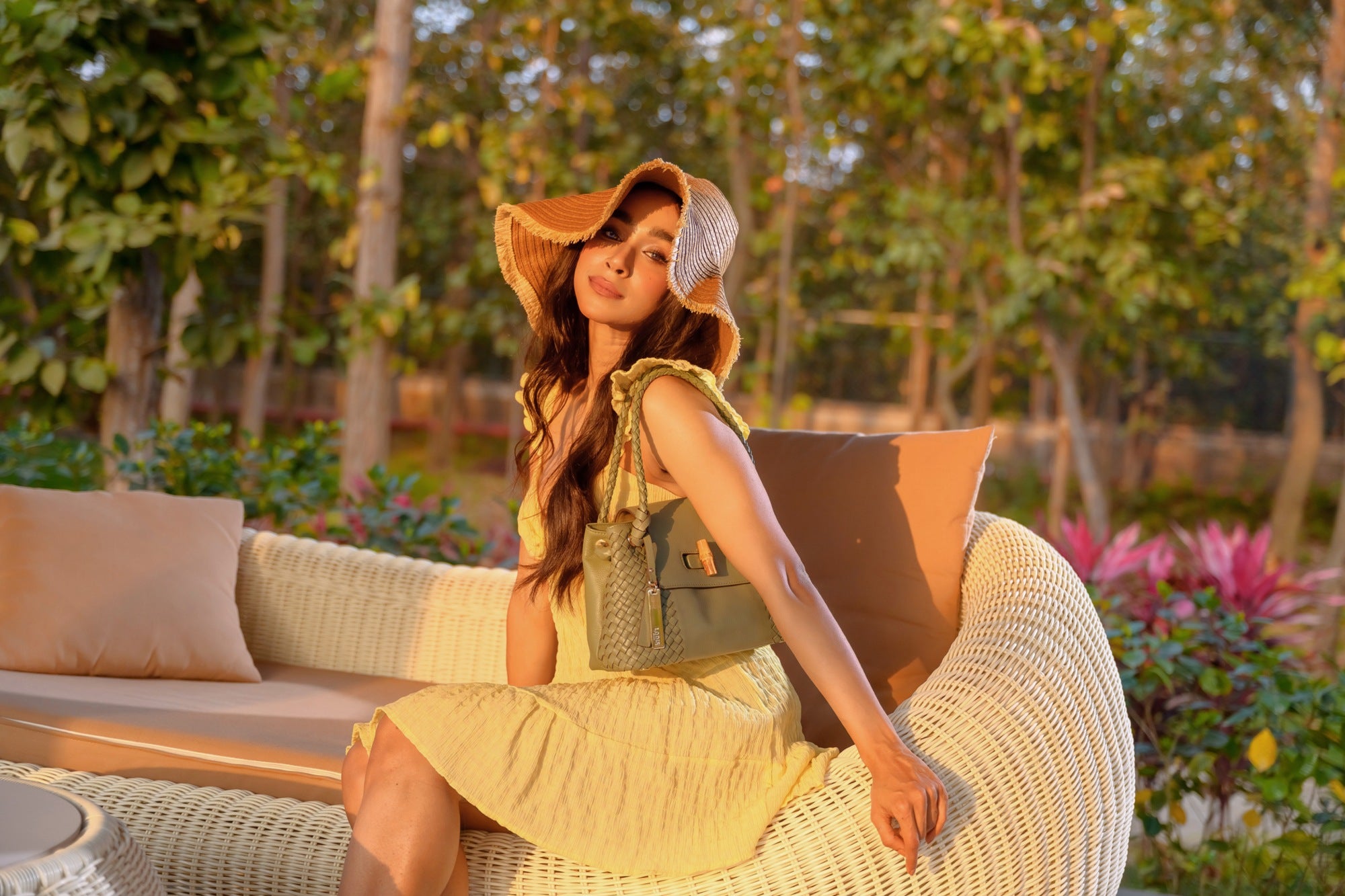 Woman in Yellow Dress Holding Lodis Sondra Satchel in Sage Green – Golden Hour Outdoor Lifestyle Shot Showing Woven Leather Panels and Bamboo Turn-Lock | Lodis 1965
