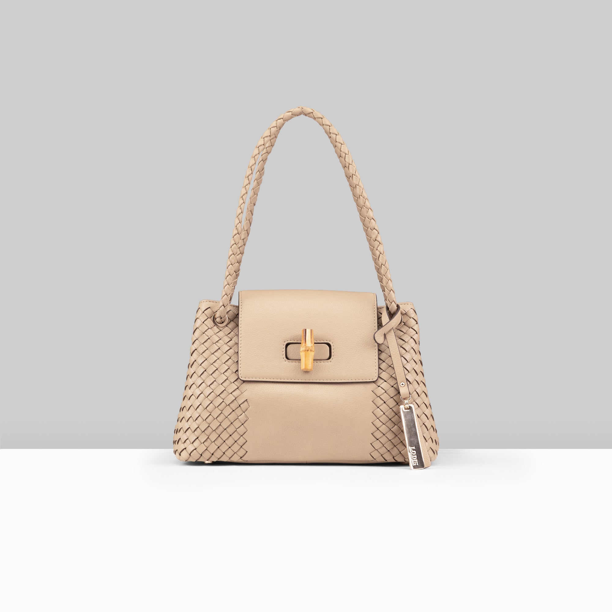 Lodis Sondra Satchel in Sand – Front View, Drum Dyed Pebbled Leather with Woven Body Panels, Bamboo Turn-Lock Flap, Braided Handle, and Lodis Tag | Lodis 1965