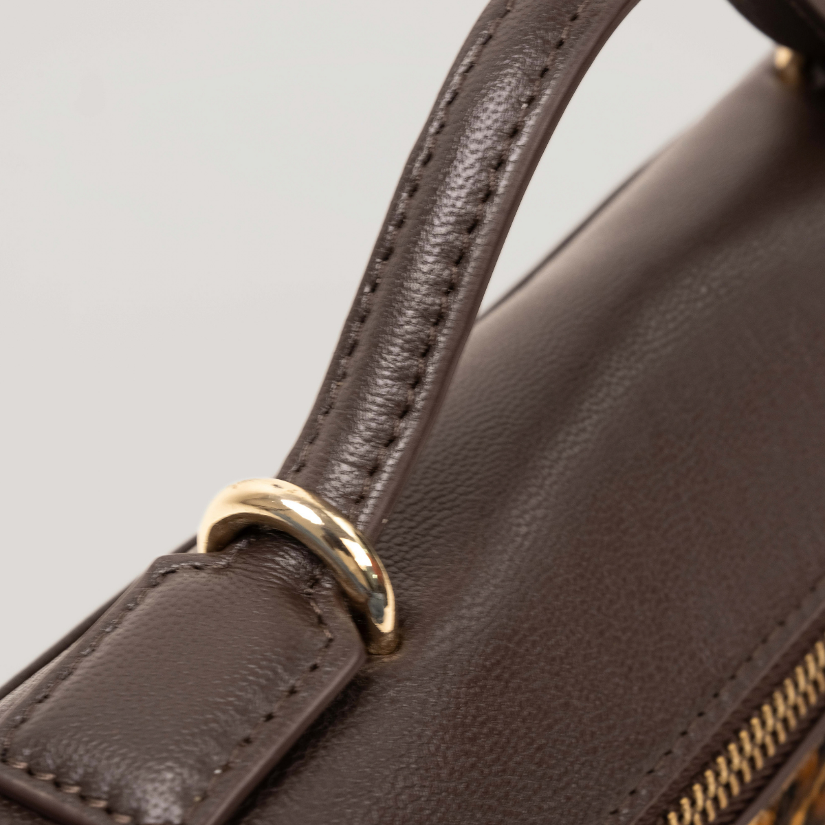 Lodis Stratos Texas Crossbody in Cheetah Print - Close-Up of Dark Brown Texas Leather Top Handle with Gold-Tone Ring Hardware | Lodis 1965