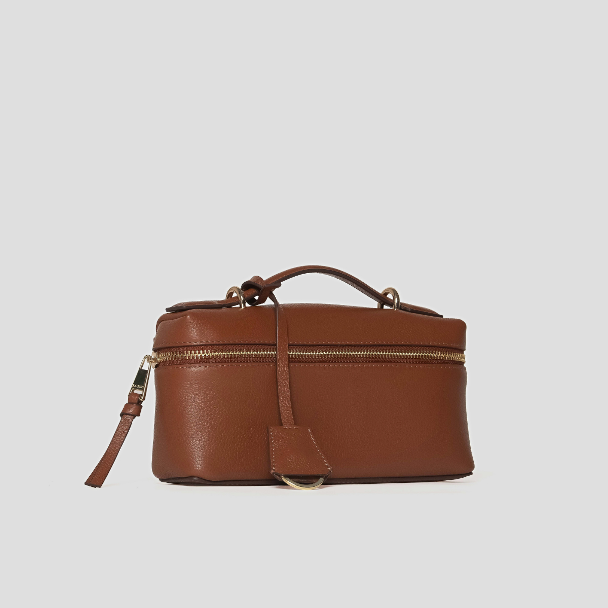 Lodis Stratos Texas Crossbody in Chestnut - Angled View Showing Top Handle, Hang Tag and Gold-Tone Zip Around Cognac Texas Leather | Lodis 1965
