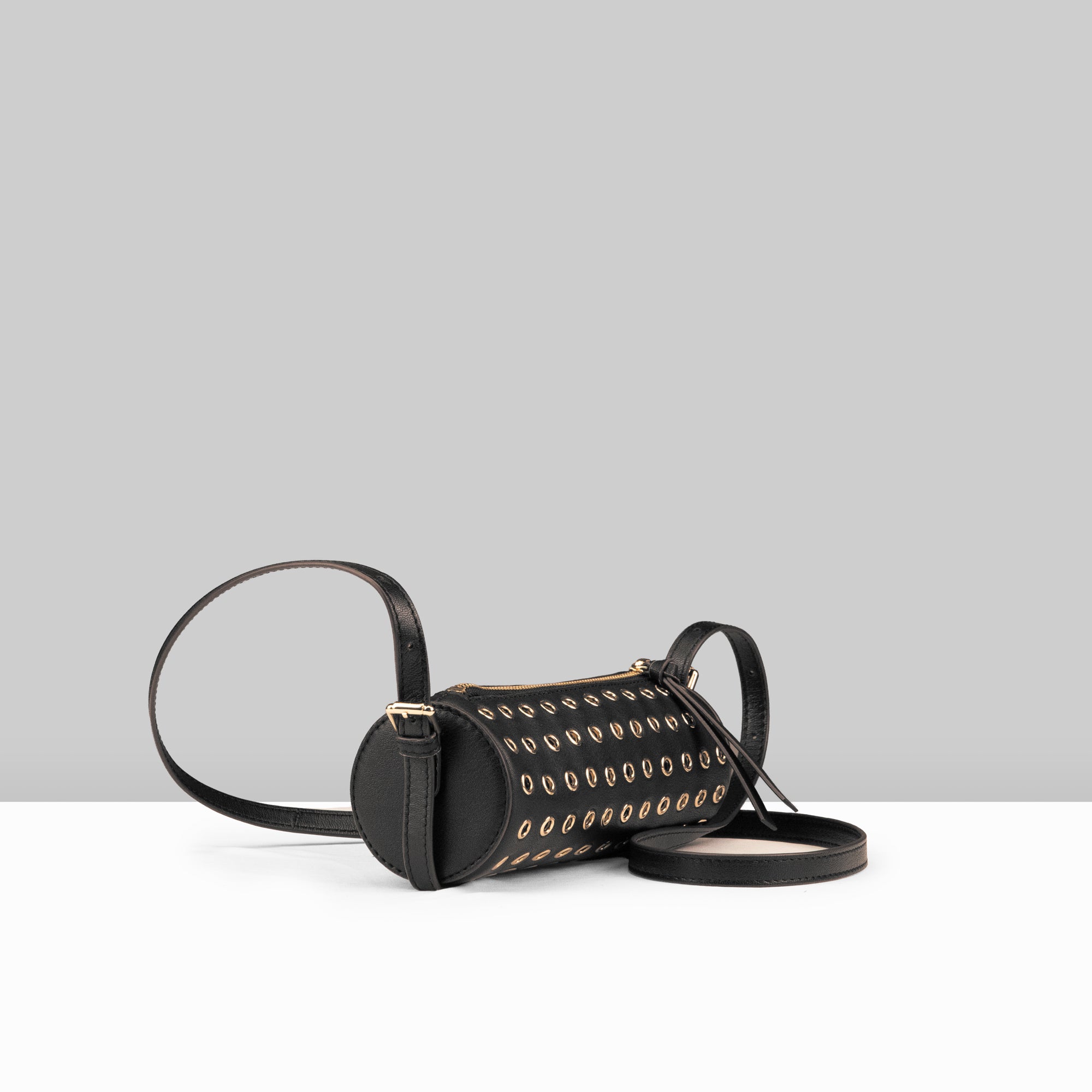 Stephanie Barrel Bag in Black Leather – Side Angle View Showing Cylindrical Shape, Gold Eyelet Studs, and Adjustable Crossbody Strap | Lodis 1965