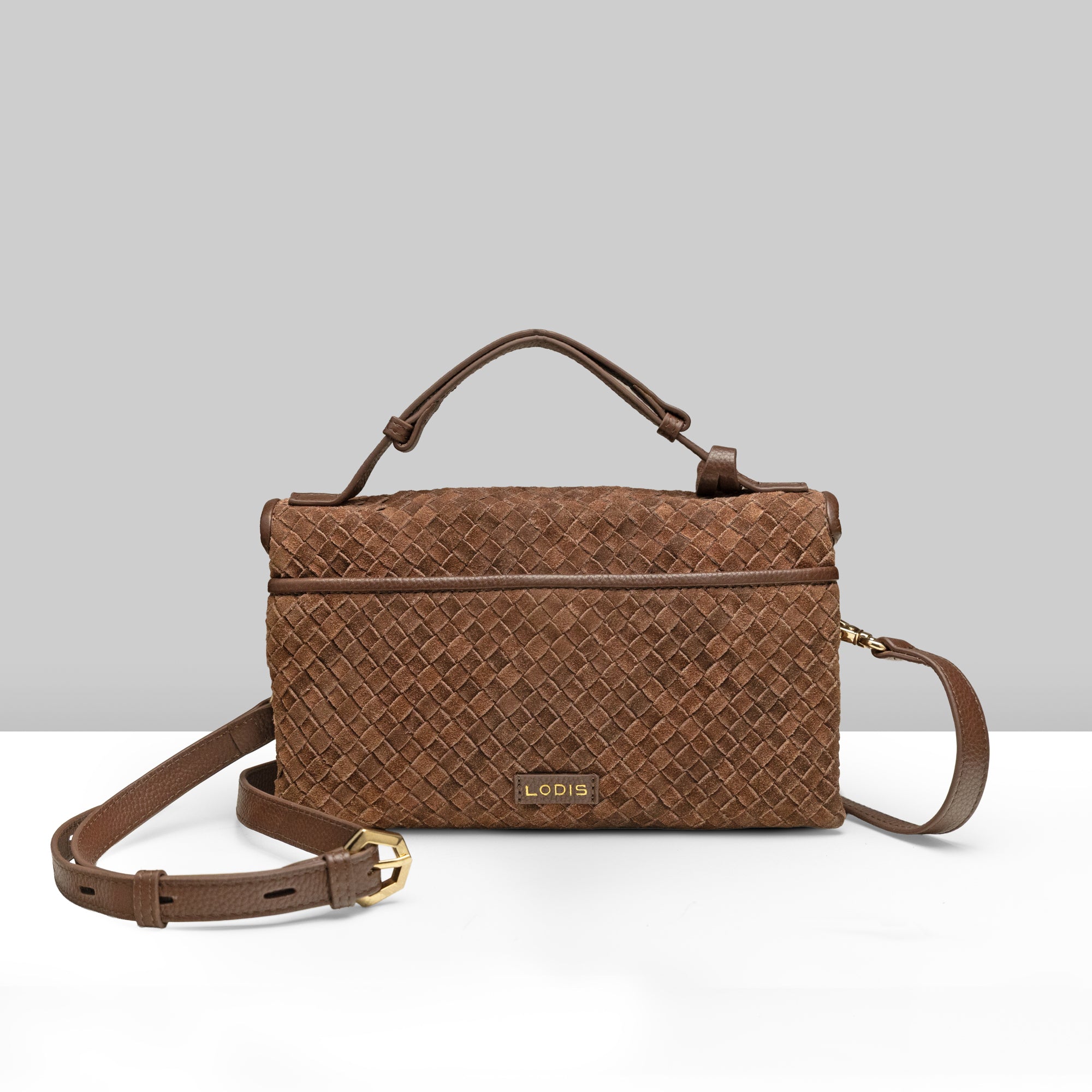 Lodis Meridian EW Crossbody chestnut woven suede leather bag showing back view with Lodis logo plate, top handle, and adjustable crossbody strap