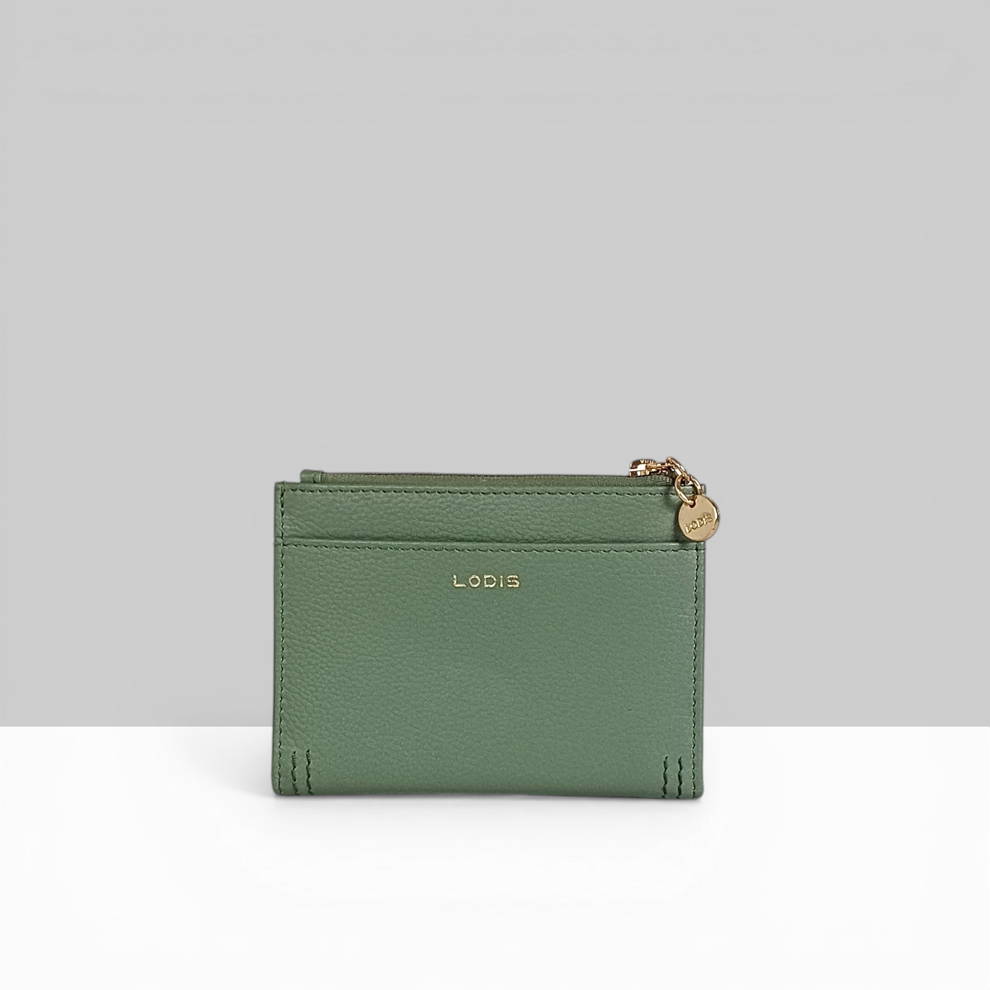 Lodis Kiara Flip Face Wallet in sage green pebbled leather showing back view with embossed Lodis logo and gold zip charm