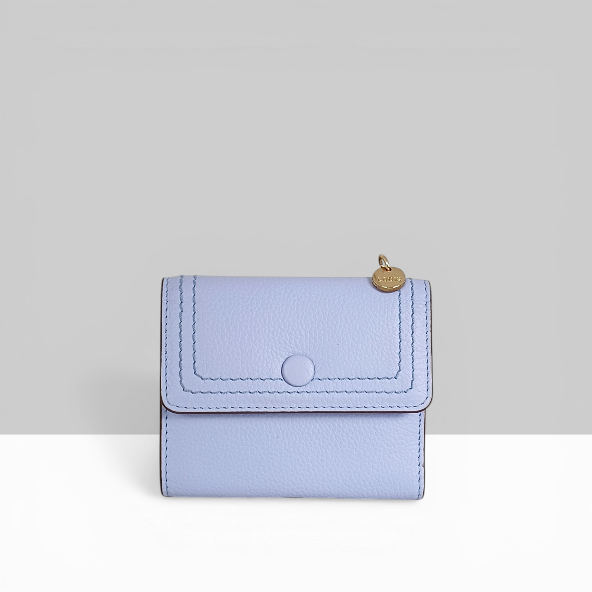 Lodis Kiara French Purse in aura lavender pebbled leather with snap closure and gold Lodis charm – front view