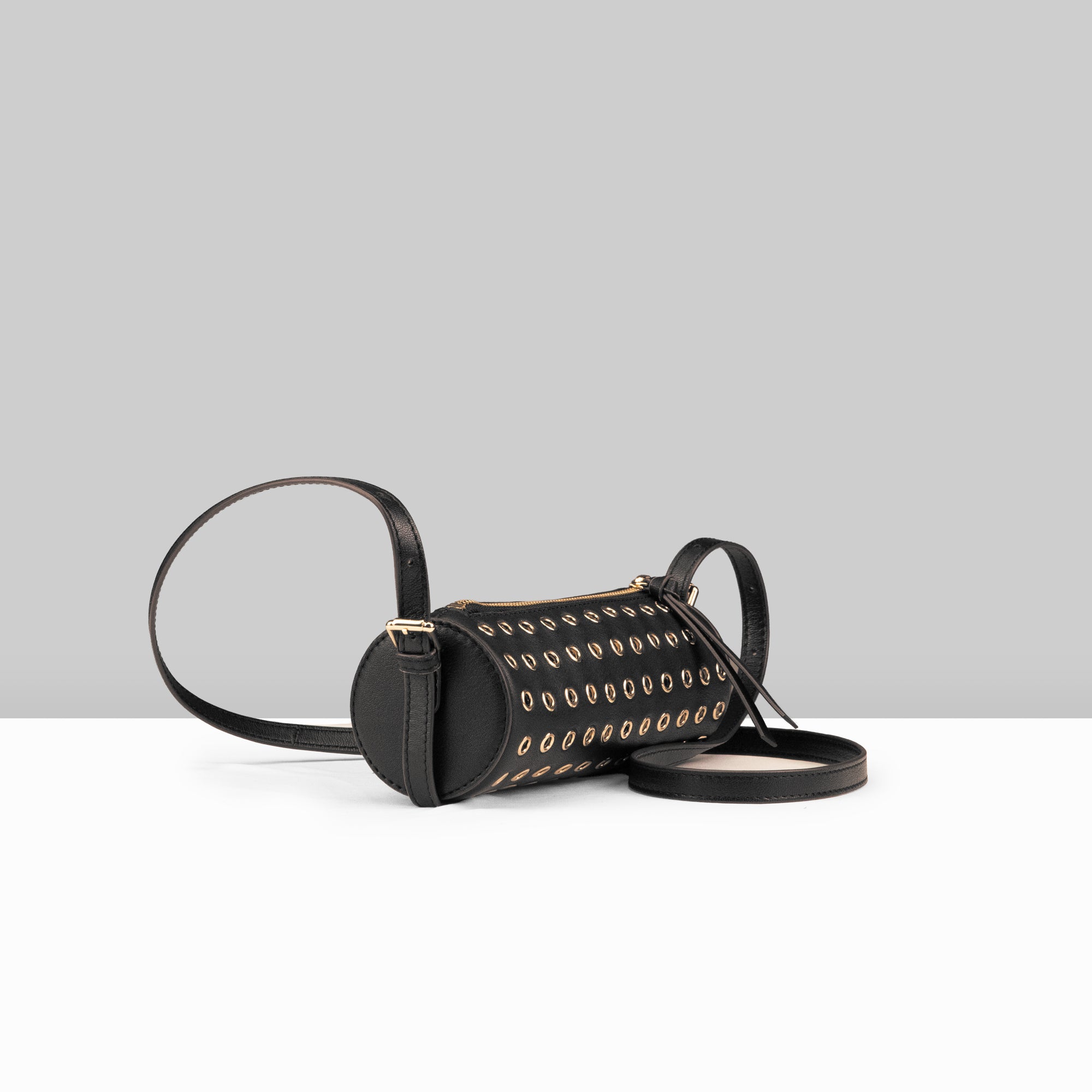 Lodis Stephanie Barrel Bag black leather crossbody bag with all-over gold grommet detail and long adjustable strap – side view