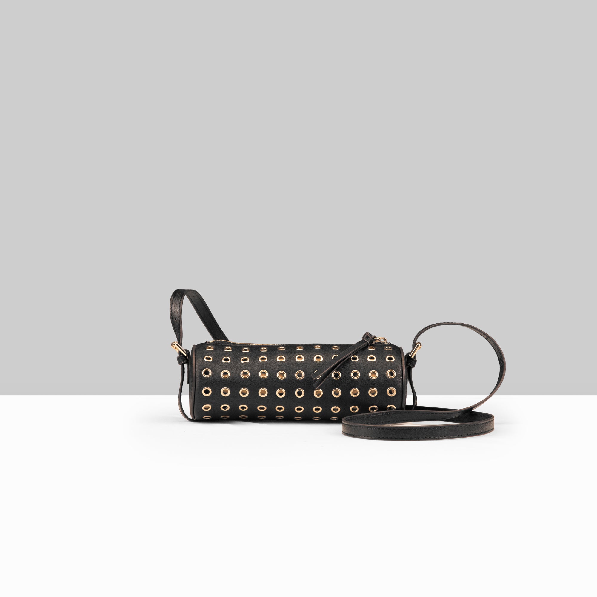 Lodis Stephanie Barrel Bag black leather crossbody bag with all-over gold grommet detail and adjustable strap