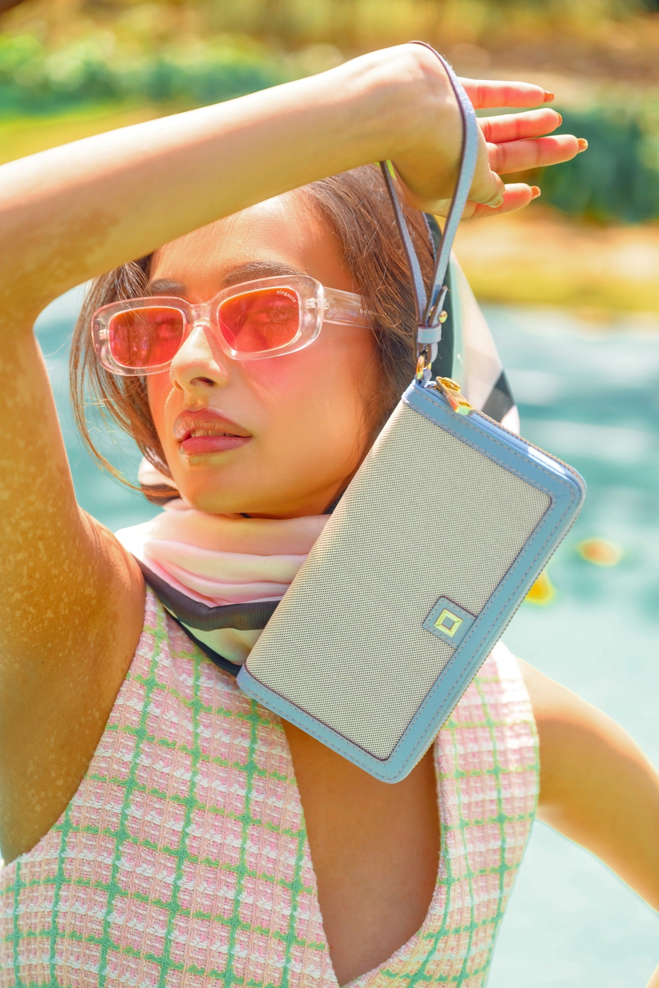 Woman Wearing Lodis Kiara Continental Zip Wallet in Aura as a Wristlet – Summer Lifestyle Shot with Colorful Outfit | Lodis 1965