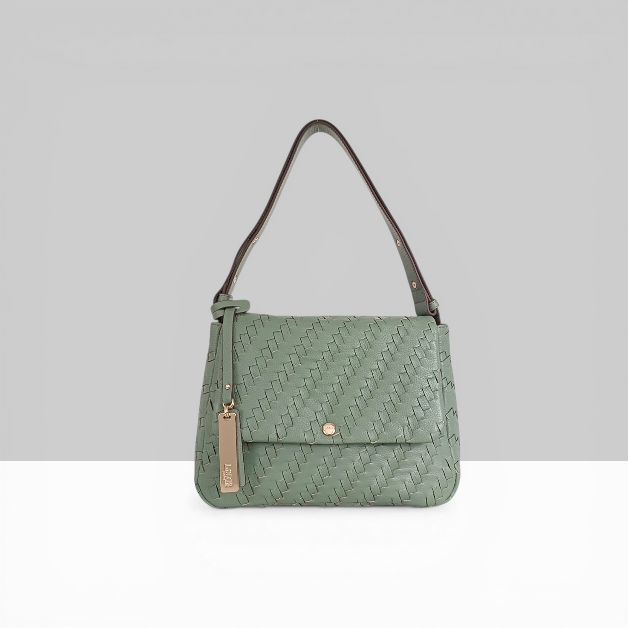 Lodis Solstice Shoulder Bag in Sage Green – Front View, Drum Dyed Woven Pebbled Leather with Flap Closure, Gold-Tone Snap and Tassel Detail | Lodis 1965