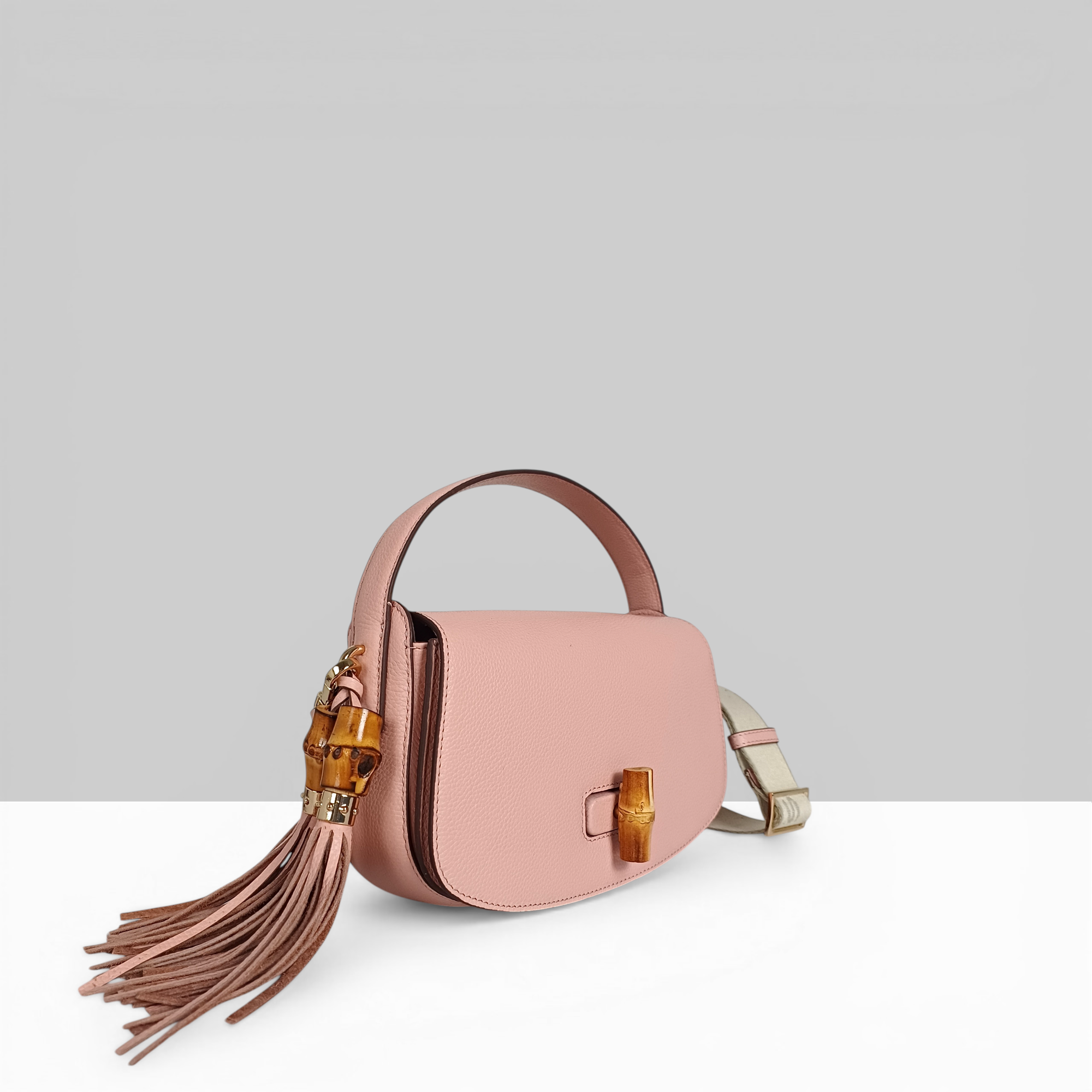 Lodis Sondra Top Handle Crossbody in Dusty Rose – Angled View Showing Bag Depth, Bamboo Turn-Lock Side Profile, Double Tassel, and Woven Crossbody Strap | Lodis 1965