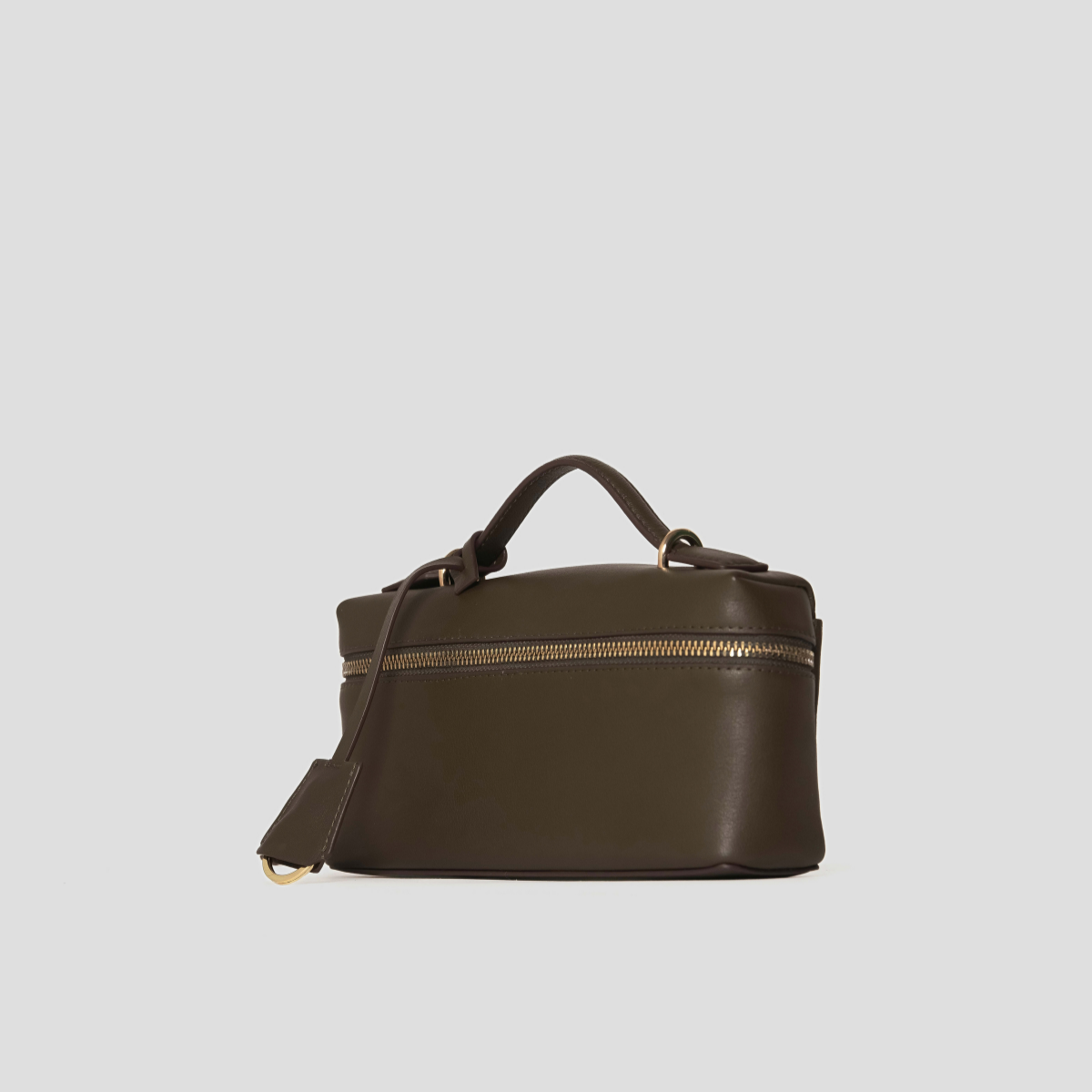 Lodis Stratos Texas Crossbody in Olivine - Angled View Showing Gold-Tone Zip Closure, Top Handle and Leather Hang Tag on Olive Green Texas Leather | Lodis 1965
