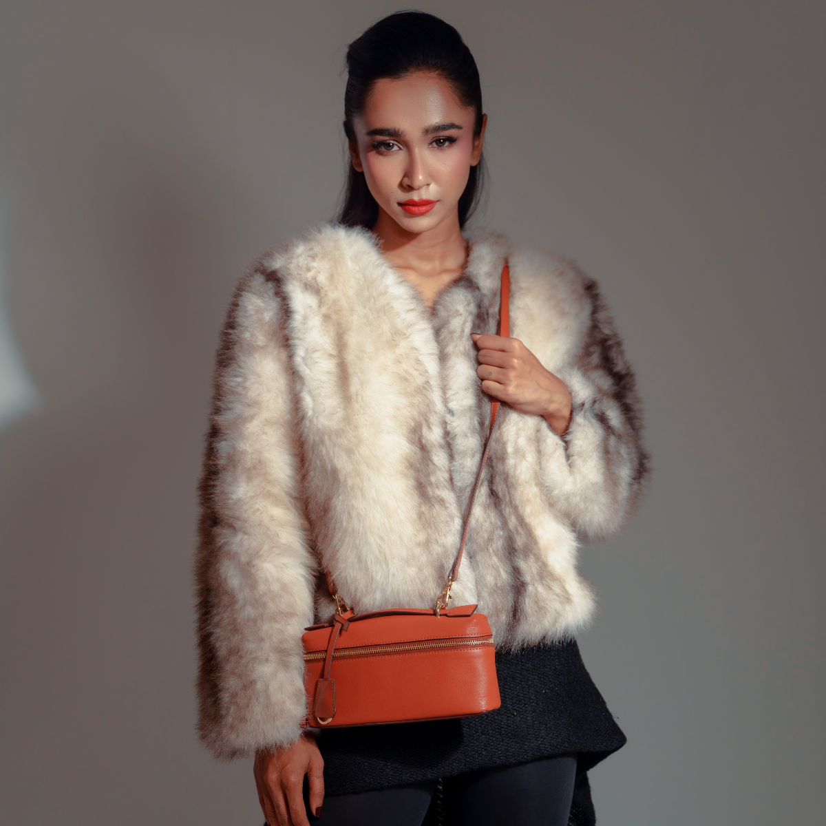 Woman Wearing Lodis Stratos Texas Crossbody in Rust - Fall Lifestyle Shot with Cream Faux Fur Jacket and Black Trousers in Studio Setting, Rust Texas Leather | Lodis 1965